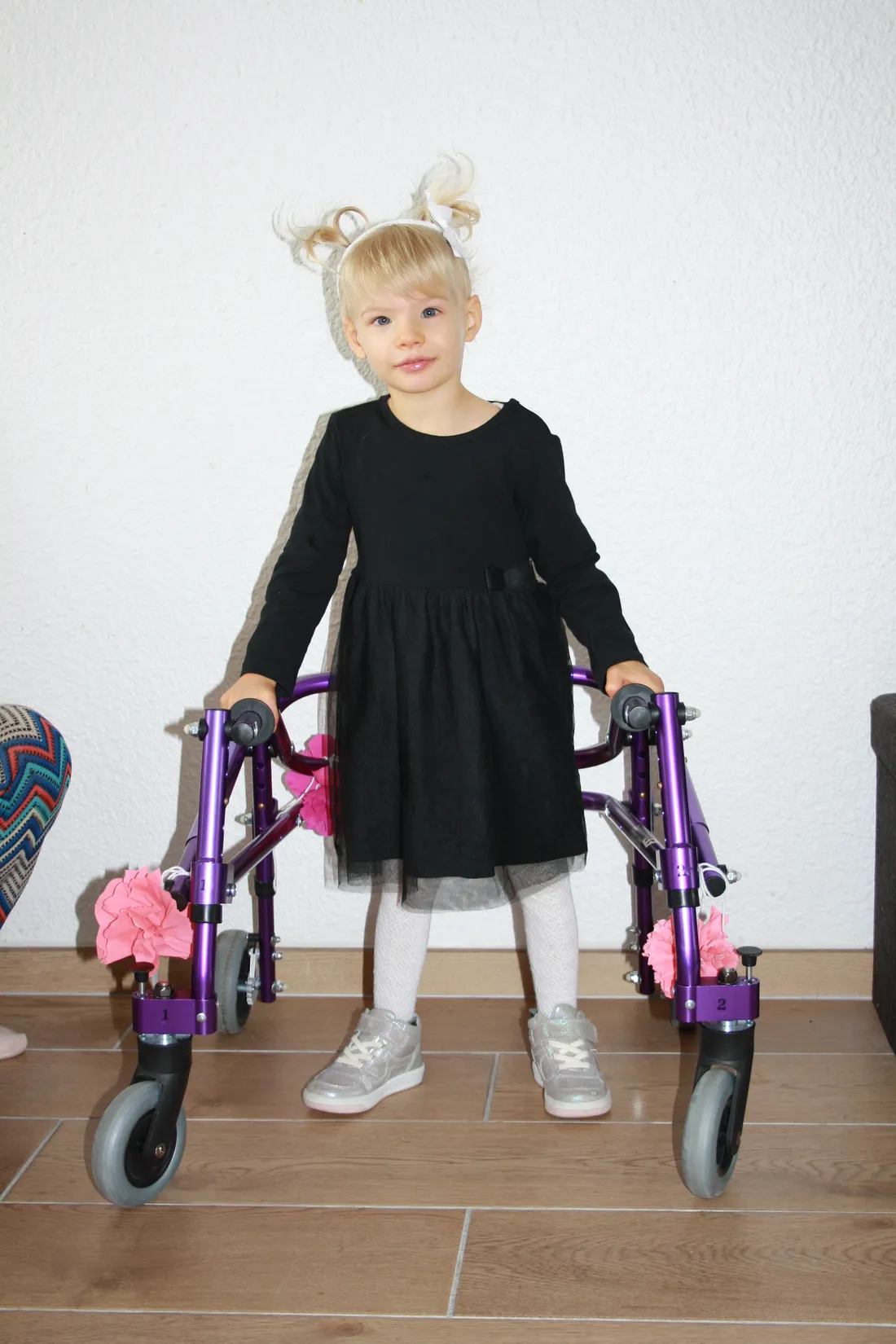 Zoé debout avec son déambulateur